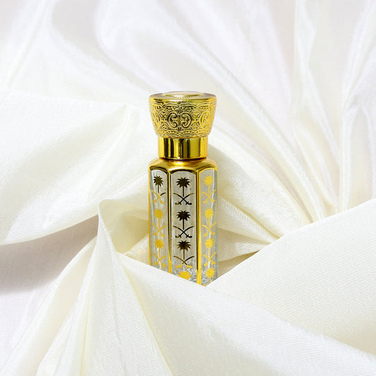 Taiba attar bottle with intricate golden design on soft white fabric background, a timeless fragrance by Jigri.